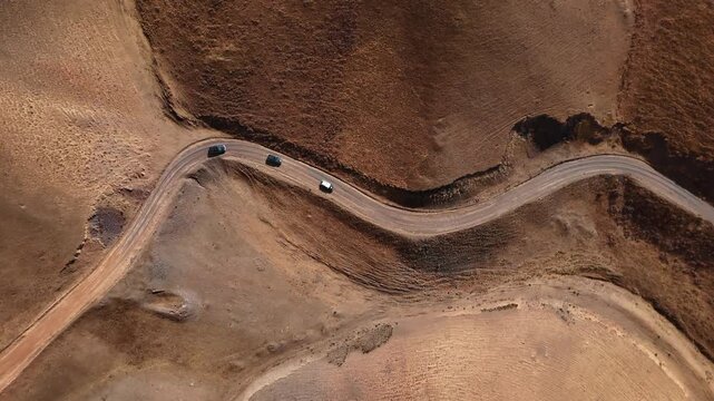 Winding Dirt Road With 4x4 Vehicles Top Down aerial view