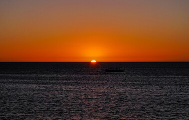 Naklejka premium Final rays of sunlight over the ocean