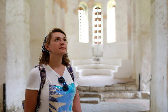 Woman tourist exploring ancient Christian church with architectural details