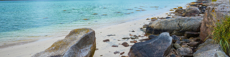 Fjord in rainy weather. Rocky beach in evening, White sand on the beach. Beautiful nature of Norway. Lofoten islands
