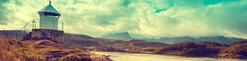 Lighthouse against dramatic cloudy sky during sunset