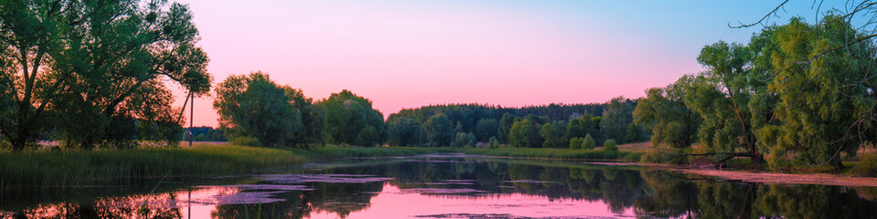 Magical pink purple sunrise over the lake. Misty morning, rural landscape, wilderness, mystical feeling