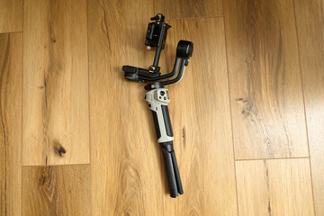 Stabilizer equipment placed on a wooden floor with light reflections at a home or studio setting