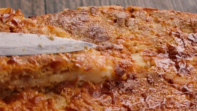 Closeup of a spatula taking a piece of sweet semolina pie. Delicious homemade dessert made of milk and dry dough with delicate texture.