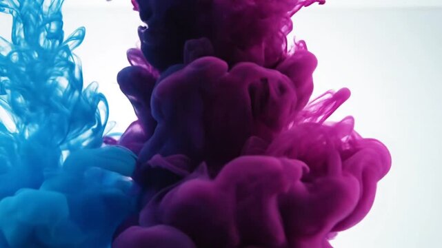 Abstract ink flow in water creating colorful forms against white backdrop