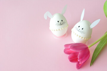 Easter Bunny Eggs and Pink Tulip on Pastel Background copy space