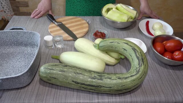 on the table ingredients for cooking zucchini caviar, Preparing vegetables for stewing at home, woman preparing a dish of zucchini