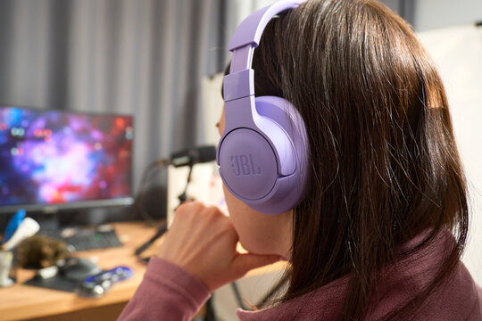 Tyumen, Russia-December 3, 2025: Listening to music with headphones jbl at home in a cozy setup