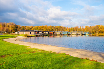 Log Cabins by a Lake and a Beach on a Tourist Resort in Arcen, Limburg, The Netherlands on sunny Autumn day in November