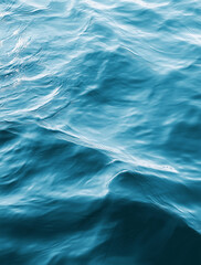Obraz premium A wide view of the deep blue ocean surface showing the rolling movement of natural waves and sunlight reflecting off the textured water.