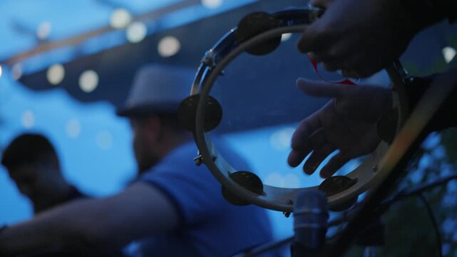 Musician playing tambourine creating rhythm at concert event