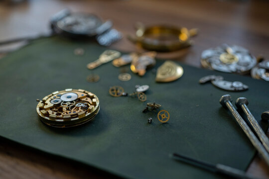 Closeup image of a watchmaker's workshop with dissembled watches and tools