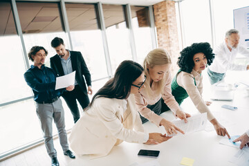 Professional team evaluating documents during an office meeting, emphasizing collaboration, teamwork