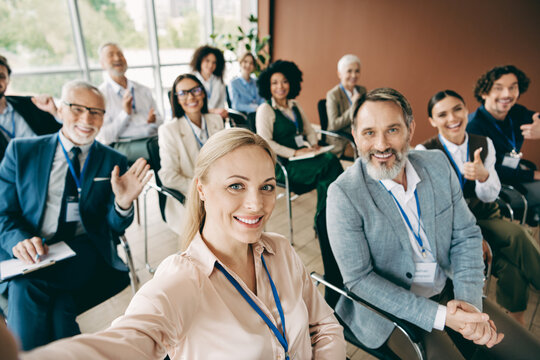 Business team gathered at a seminar, sharing positivity and ideas with smiling faces and diverse backgrounds in a modern office