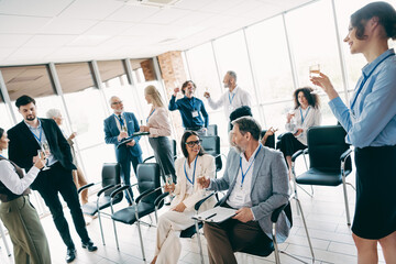 Professional team having a casual discussion and networking in a bright office environment, sharing...