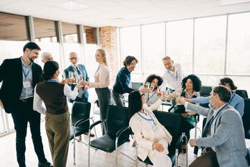 Group of business professionals celebrating with glasses in a modern office space emphasizing teamwork and collaboration