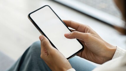 A person holding a smartphone with a blank screen, suggesting potential for digital interaction or mobile use.