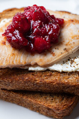 Open Sandwich with leftover turkey slices with cranberry sauce on top. Perfect holiday breakfast or lunch