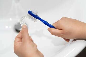 Cleaning tooth aligners.Washing and removing organic residues with a plastic toothbrush from...