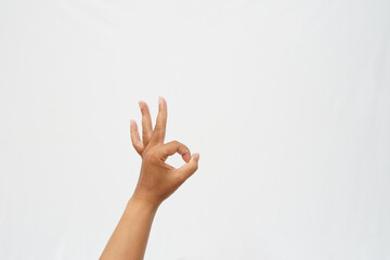 Left hand showing okay gesture with index finger and thumb touching on white background, Perfect for success, approval, and positive communication symbol