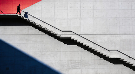 赤い光へと上昇するコンクリート階段と人物のシルエット