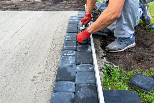 Laying paving stones in the garden for a large expansion pool.
