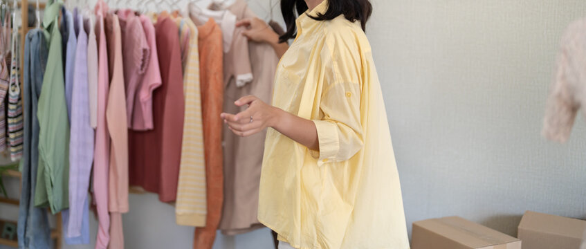 Young Asian girl&nbsp;Online consultation with stylist designer take online video course or training of stylish clothes on hangers clothing Asian Woman dressmaker working in fashion studio