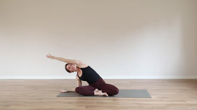 A young woman practicing yoga in a bright modern studio, focusing on balance, breathing, and mindfulness.