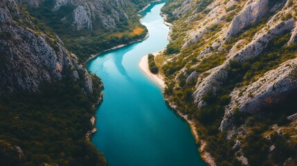 Aerial view of a turquoise river winding through rocky canyons