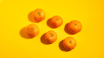Fototapeta premium Fresh Mandarins on a Bright Yellow Background