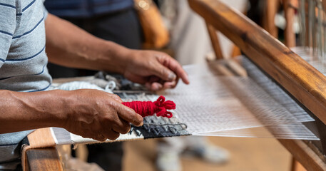 Indigenous man weaving textiles and fabrics, Otavalo, Ecuador.