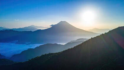 Majestic sunlit mountain peak pierces misty valleys at dawn