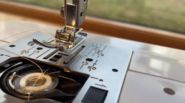 close up threading the under thread of a sewing machine