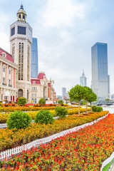 Fototapeta premium Flowers in front of the tower on Jinwan Plaza square in Tianjin, China