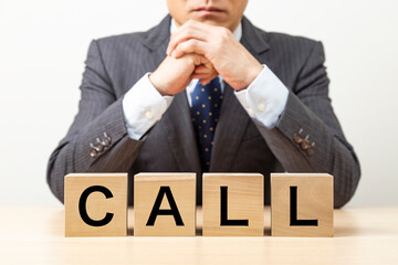 Obraz premium 「CALL」と書かれたブロックとビジネスマン