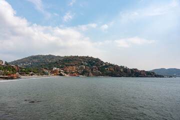 Fototapeta premium La Madera Beach in Ixtapa Zihuatanejo, Costa Grande, Guerrero. Coastal scene surrounded by hotels and tourists enjoying the sea and sun. Mexico, January 19, 2026
