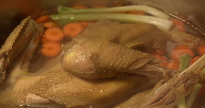 Organic chicken broth is boiling. Homemade chicken broth.