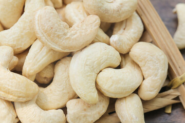 Fototapeta premium Ripe Cashew Nuts on Wooden Board - Fresh Delicious Snack