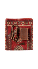 Fototapeta premium A folded red prayer rug, a holy Quran in a leather cover, and wooden prayer beads are arranged for Islamic prayer on a transparent background.