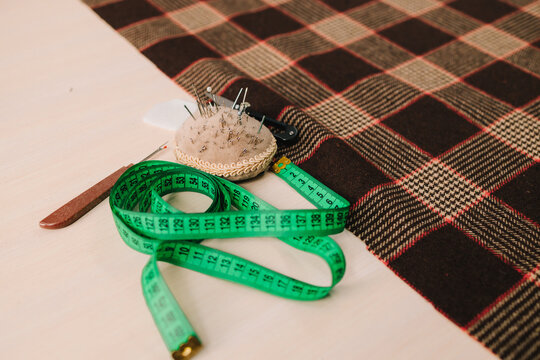 Sewing tools sit on table with fabric, organized for cutting, sewing, and garment creation.
