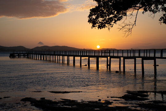 Wooden pier jetty dramatic sunset orange sky silhouette Buzios Brazil travel photography
