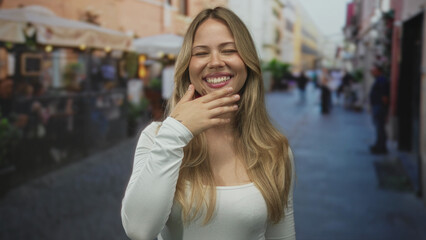 Fototapeta premium Woman with blonde hair raising hand to forehead on busy city street; curiosity exploration wonder discovery.
