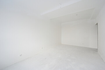 Obraz premium spacious, empty room with white walls and floor, minimalist design, one radiator, recessed ceiling lights, a doorway leading to another space, no furniture, clean and bright.