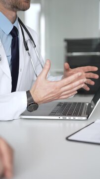 Doctor consulting patient, typing on laptop during medical check up in clinic, accessing electronic health records. Medicine, healthcare and science concept