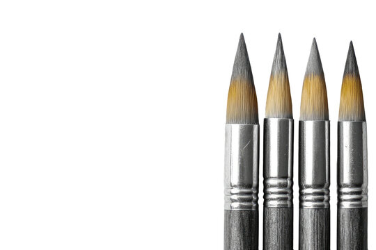 Four pointed paintbrushes on black background, tightly grouped