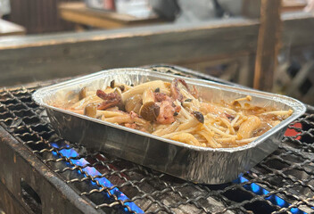 炭火で焼かれたイカときのこのホイル焼き