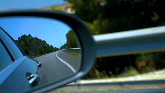 Street view of a spanish freeway in the back mirror of a driving car. on a sunny spring day