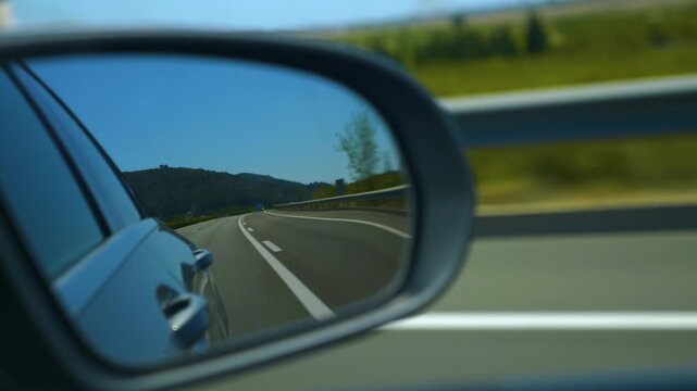 Street view of a spanish freeway in the back mirror of a driving car. on a sunny spring day
