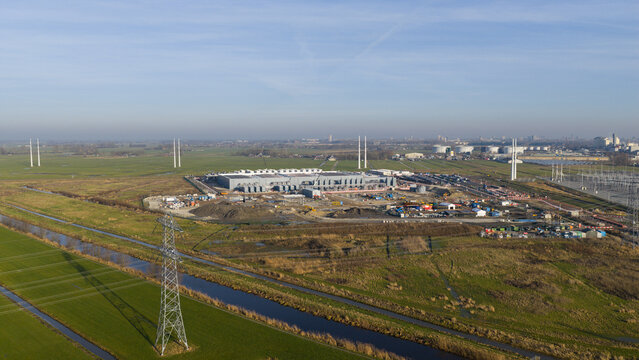 Groningen, Netherlands - 20 January 2026: Aerial view of a vast construction site, where the skeletal frame of a new data center rises amidst the flat, green landscape.