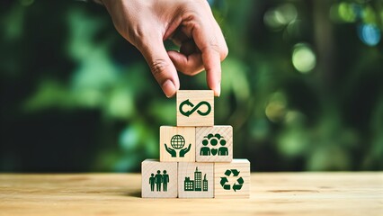 Hand placing a block with infinity loop symbol on top of other blocks representing sustainability concepts